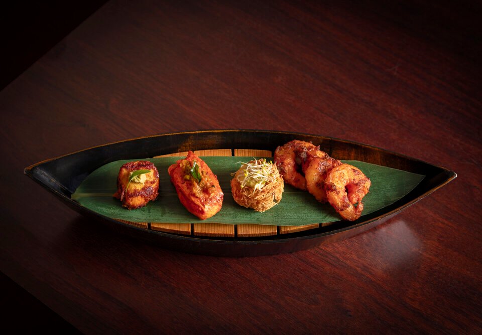 Interior of Quilon, a Michelin-starred South Indian restaurant in London, featuring elegant coastal-themed decor.