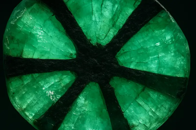 A Trapiche Emerald showing the black six-spoked wheel pattern.