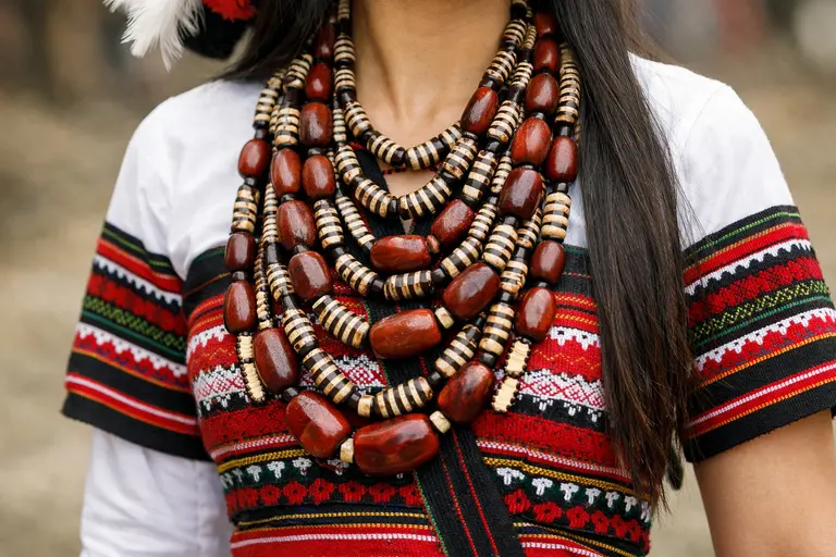 A Mizo woman wearing a traditional Puanchei and a multi-strand Mizoram Jewellery necklace.